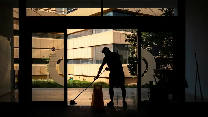 Cleaner mopping a building lobby after hours