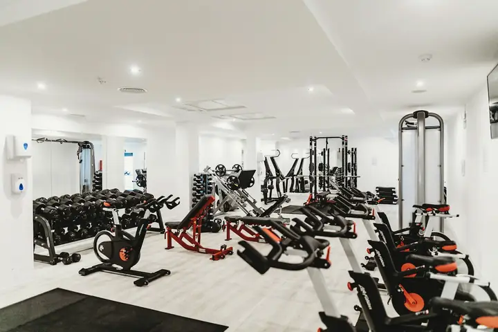 Bright gym floor with bikes and weight machines