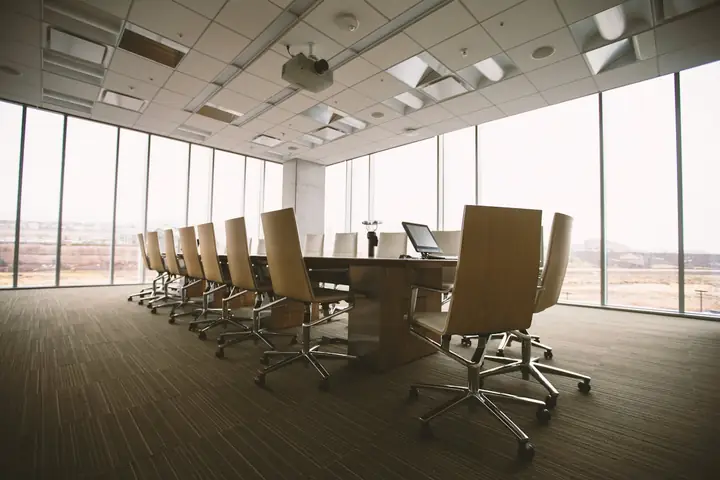 Carpeted meeting room with long table and chairs